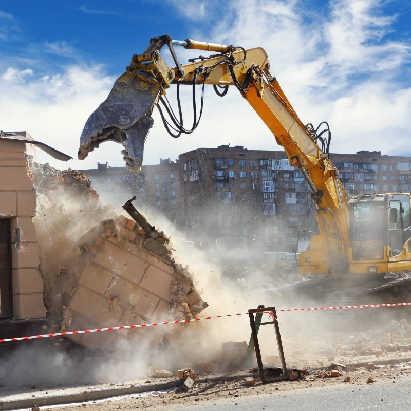 Démolition d'un immeuble avec un engin de BTP.