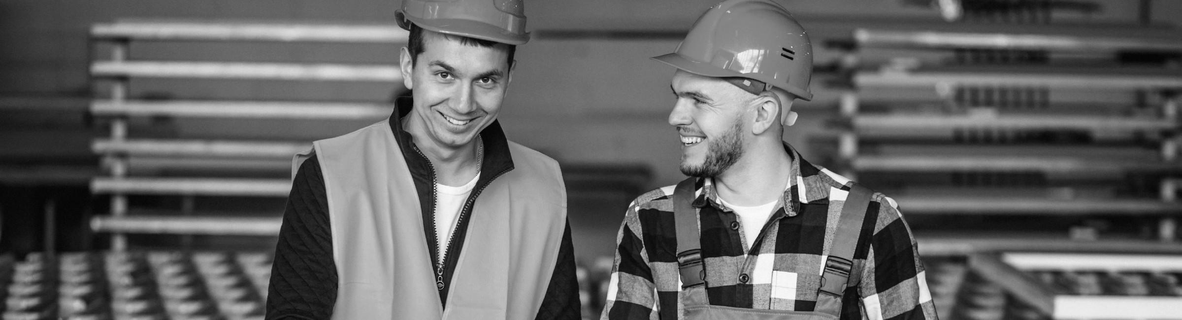 Deux collègues sourient dans une usine de production